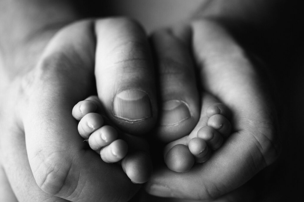 dad holding baby toes detail photo