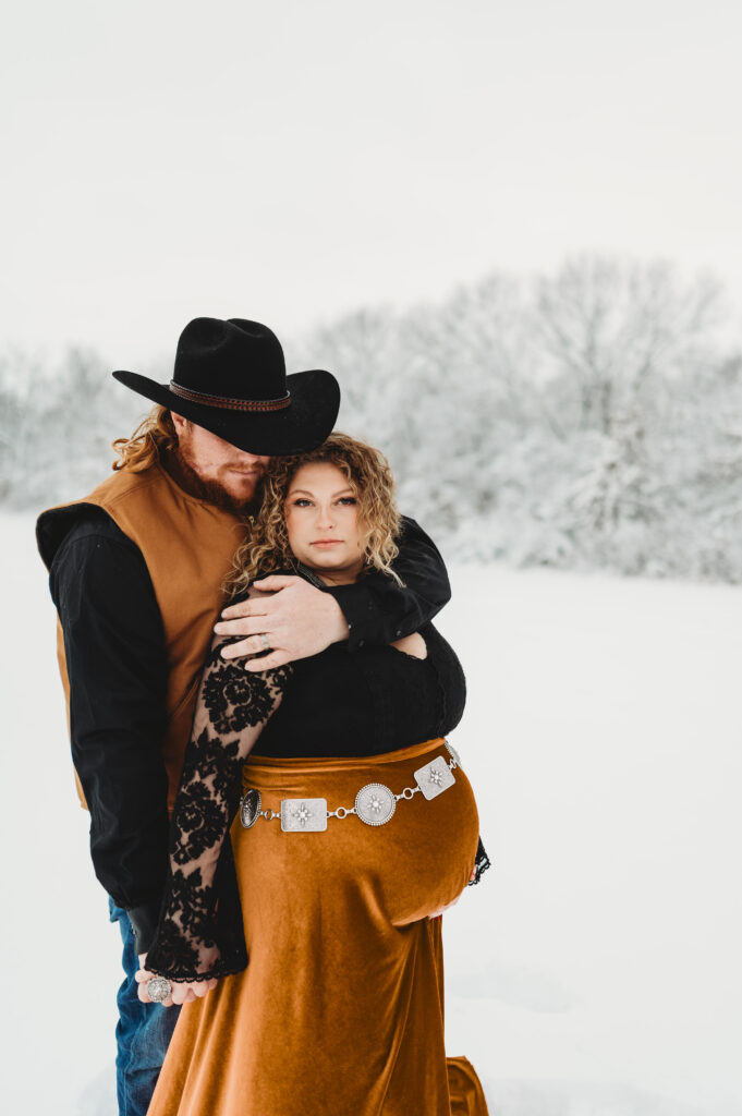 maternity photo of a couple in the snow