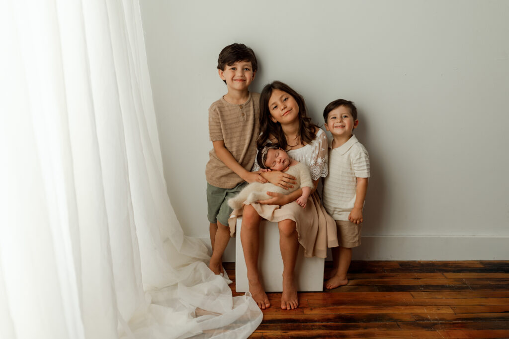 siblings posed in a newborn studio