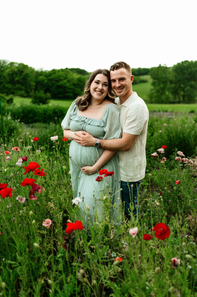 couple posed in flowers maternity photos